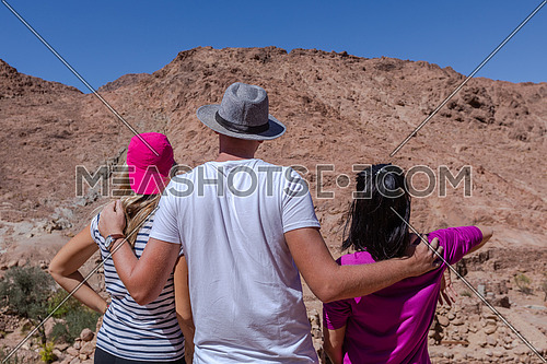 Group of tourists from behind exploring Sinai Mountain for wadi Freij at day.