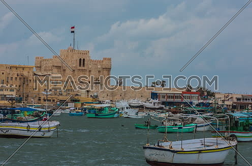 Track Right Long Shot outside Citadel of Qaitbay shows fishing boats at day
