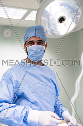 Portrait of a young middle eastern doctor with gloves on his hands in the modern clinic