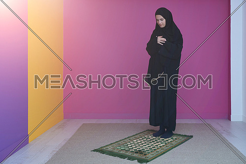 Muslim woman in namaz praying to Allah, God. Muslim woman on the carpet praying in traditional middle eastern clothes, Woman in Hijab
