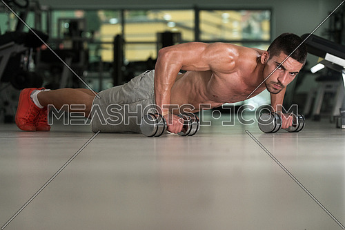 Young Athlete Doing Pushups With Dumbbells As Part Of Bodybuilding Training