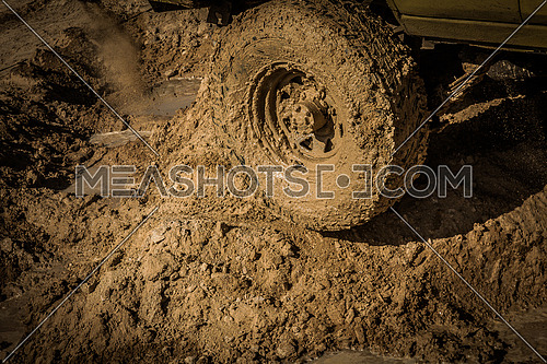 Wheels of a racing car spinning  on a Mud track
