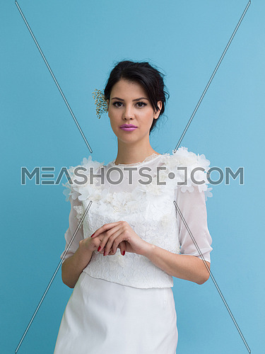 Portrait of beautiful young women in wedding dress isolated on a cyan background