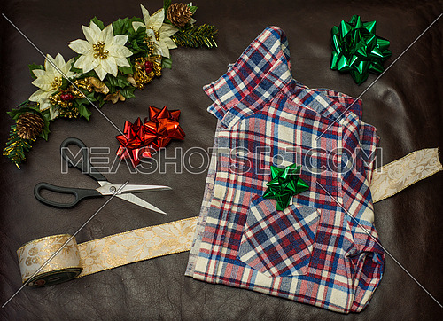 Christmas gift wrapping a men's plaid shirt.