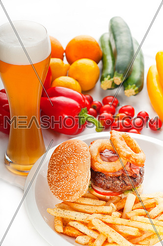 classic american hamburger sandwich with onion rings and french fries,glass of  beer and fresh vegetables on background,  MORE DELICIOUS FOOD ON PORTFOLIO