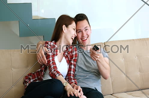 Young couple watching tv in the living roonm 