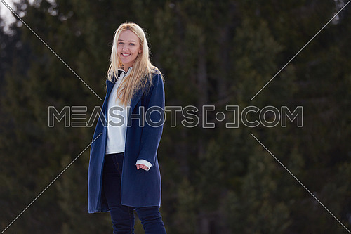 portrait of beautiful young blond woman in snow scenery