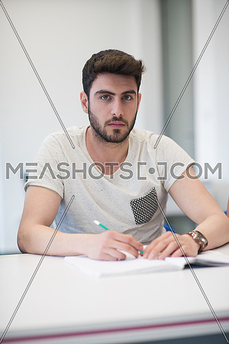 male student taking notes in classroom. business education concept, casual young businessman on seminar training