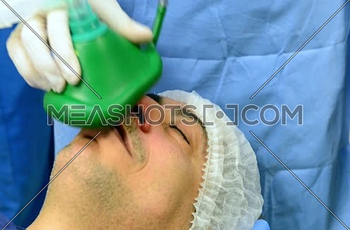middle eastern doctors in operating room giving patient anesthesia mask