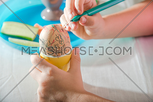 girl hand coloring easter egg