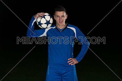 Soccer Player And Ball On Football Stadium Field Isolated On Black Background
