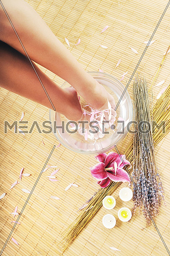 woman spa pedicure foot treatment with water and flower