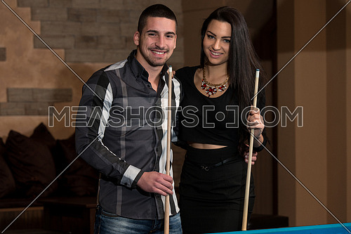 Portrait Of A Young Couple Playing Billiards