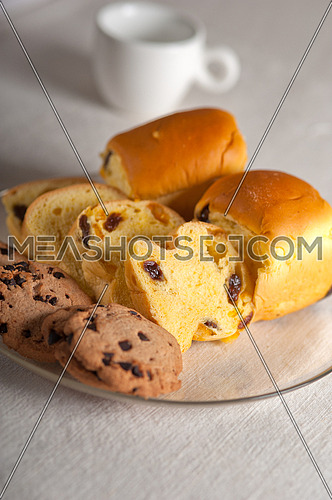 selection of sweet bread and cookies for breakfast with empty coffee cup on side