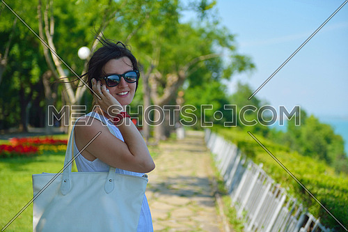 Pretty young business woman using mobile phone outdoor