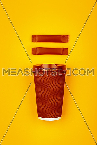 Close up one crimped disposable brown paper takeaway cup and two sugar stick sachet over vivid yellow background, flat lay, elevated top view, directly above