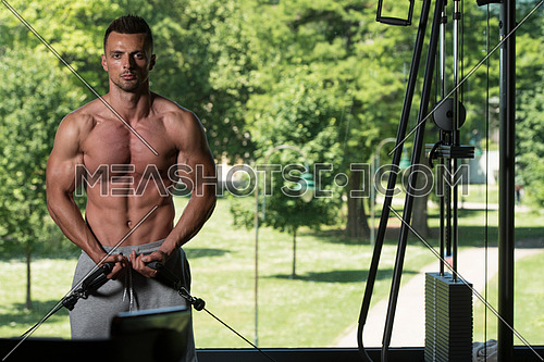 Muscular Young Man Bodybuilder Doing Heavy Weight Exercise For Chest On Cable Machine