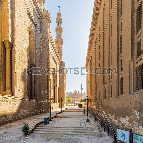 Pedestrian passage separating Royal era Mosque of Al Rifai and Mamluk era Mosque and Madrassa of Sultan Hassan, with facade of Mosque of Qanibay AlRamah at the far end, Old Cairo, Egypt