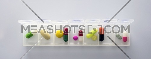 weekly pillbox with medication, conceptual image, horizontal composition