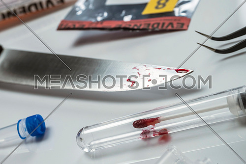 knife Spotted with blood along with a evidence bag in scientific laboratory, conceptual image
