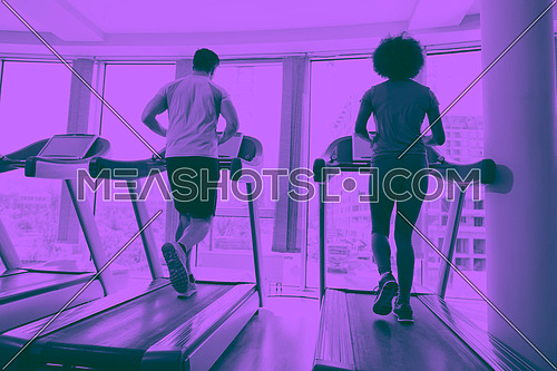 young people exercisinng a cardio on treadmill running chine in modern gym duo tone filter
