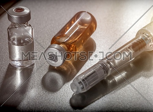 Some vials next to a syringe