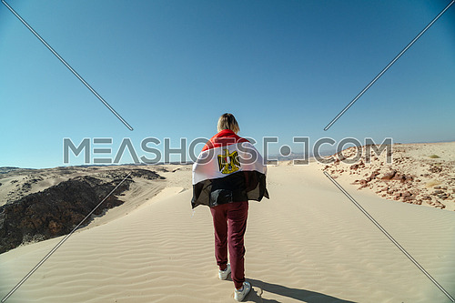 Female tourists spreading Egyptian flag while exploring Sinai Trail from Ain Hodouda by day.