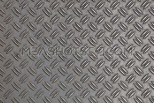 Dark gray industrial anti slip embossed metal steel plate with double diagonal bumps of diamond pattern texture, background, close up