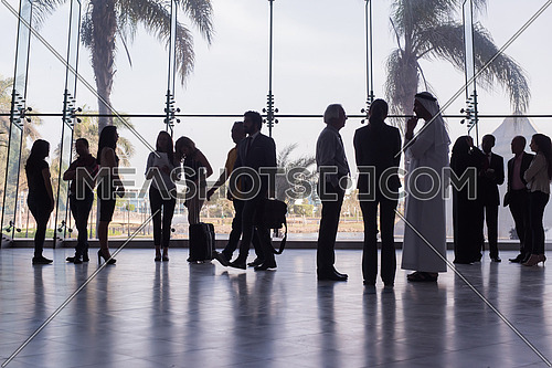 silhouette of multi ethnic people group on meeting and posing by window