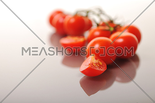 small wet fresh red tomato group isolated on white with glossy surface reflection