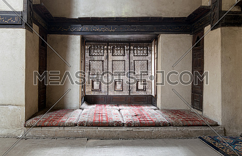 Interleaved wooden window (Mashrabiya) with built-in couch, and an embedded wooden cupboards at El Sehemy house, an old Ottoman era house in Cairo