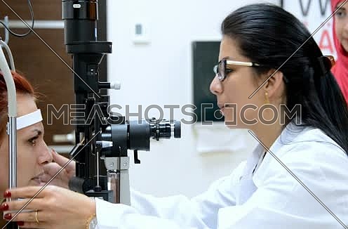 female ophthalmologist checking patient eyes using machine