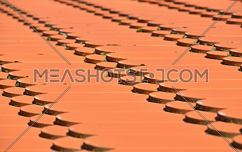 Traditional red brown ceramic roof tiles pattern background, close up, low angle diagonal view
