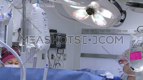 Medium shot for Operating room, lights and surgical technicians during heart Surgery