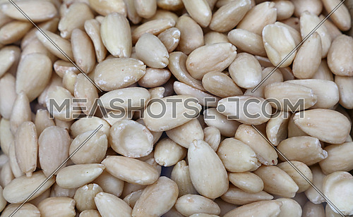 Whole white peeled almond nuts on retail market, close up, background, high angle, elevated top view