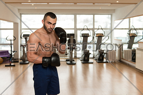 Young Muscular Sports Guy In Gloves With A Naked Torso Boxing