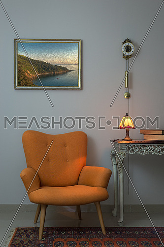 Vintage Furniture - Interior composition of retro orange armchair, vintage wooden beige table, illuminated antique table lamp, old books, and pendulum clock over off white wall and orange carpet