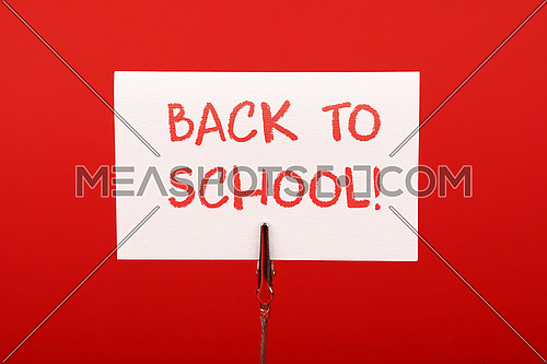 Back to school white crayon handwritten sign over red paper background with copy space