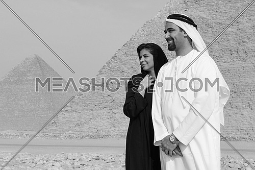 a black and white portrait of Emiratie man and his wife as tourists at the pyramids