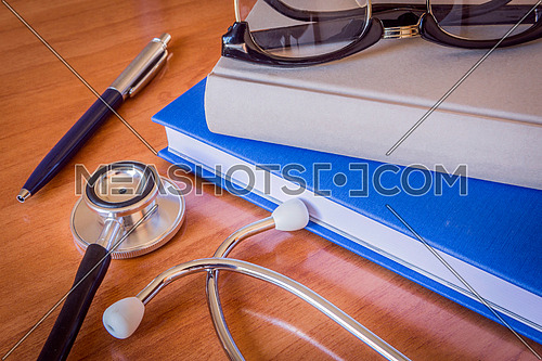 stethoscope and a book on brown background