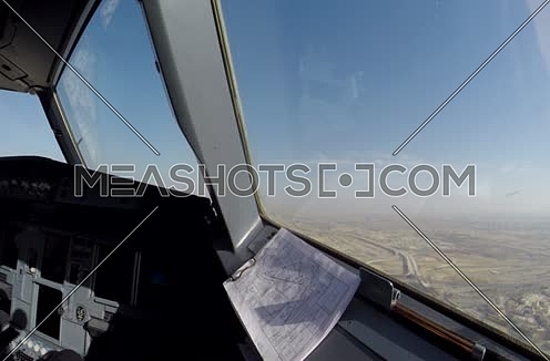 inside cockpit shot  flying over a city at day