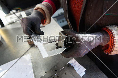 a woman working in a modern factory for the production and processing of metals, preparing and measures materials that go to the processing of CNC machines. High quality photo