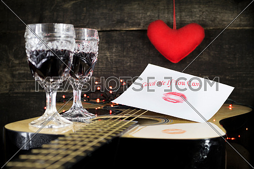 Happy Valentine's Day Kiss On White Paper With Text On it, Resting on Acoustic Guitar With Vine Glasses, Lights and Heart