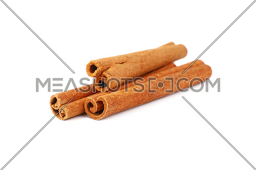 Close up heap of three cinnamon sticks isolated on white background, high angle view