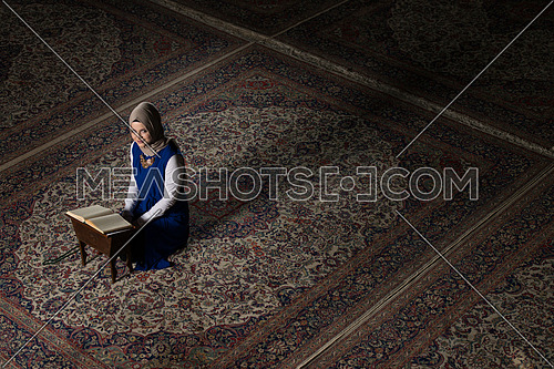 Young Muslim Woman Is Reading The Koran In The Mosque