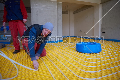 grouo of workera installing underfloor heating and colling in modern home