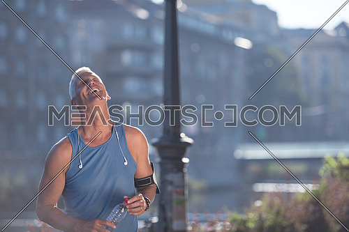 portrait of handsome senior jogging man while relaxing  and take break after morning run