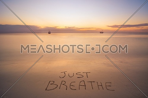 Handwritten just breath on sandy beach at sunset,relax and summer concept,Dominican republic beach.