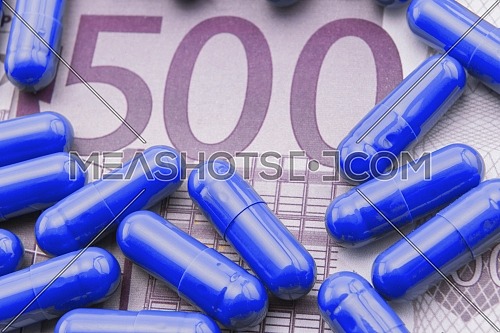 Blue capsules up ticket of 500 euros, concept of health copay