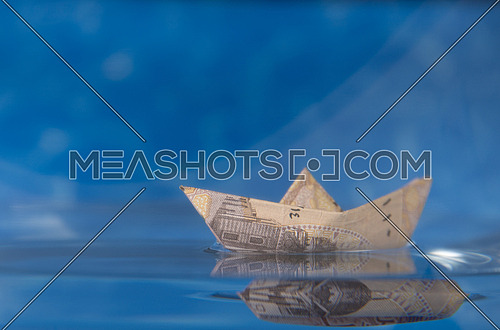 one Egyptian Pound folded like paper boat floating in water concept